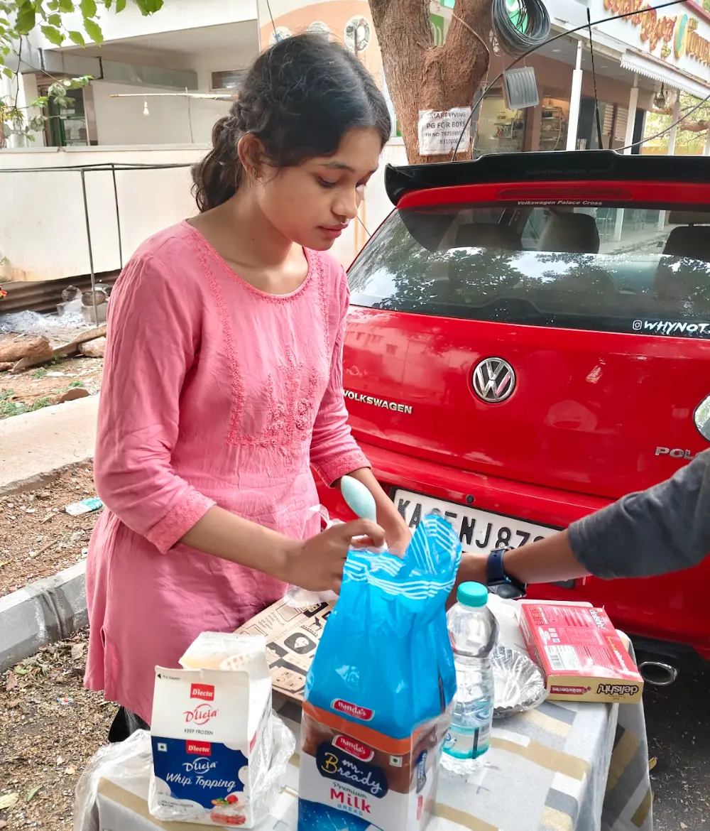 Student preparing desserts at a roadside stall